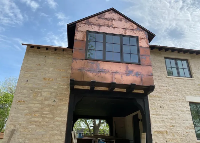 Copper metal panel facade on a stone building for Skylight Installation in Gonzales